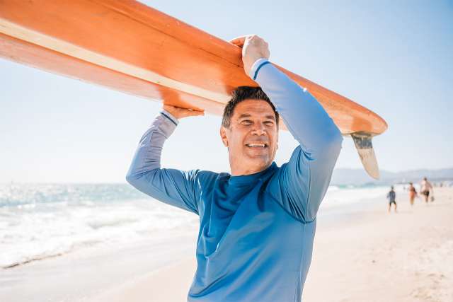 Older male surfer on beach