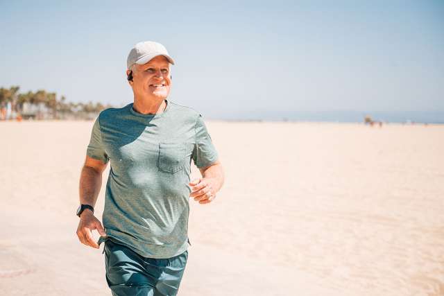 Older male running on the beach