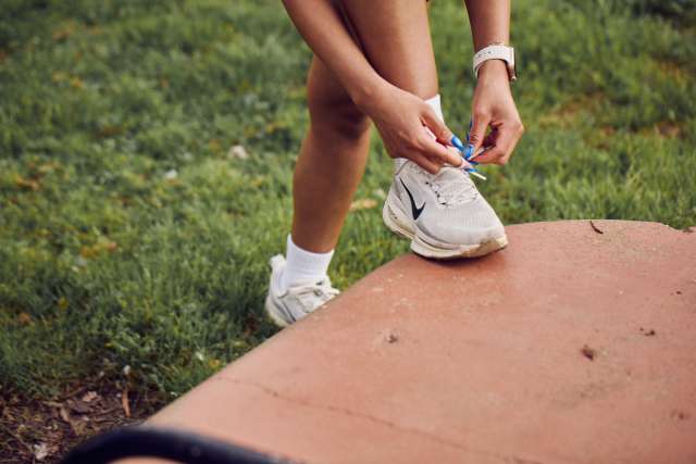 A runner ties her shoes.
