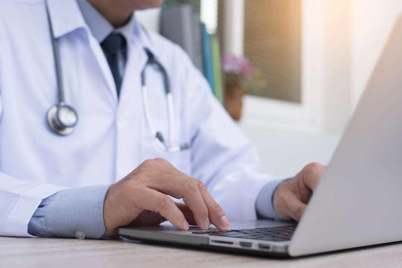 Doctor typing on computer